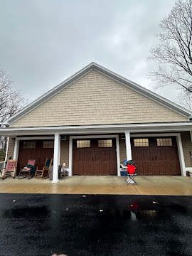 Finished detached three-car garage exterior with gable roof and covered porch