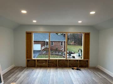 Interior remodel with new triple window opening framed in wood and luxury vinyl plank flooring