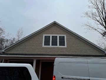 Garage gable end with new shake siding and trimmed triple attic window