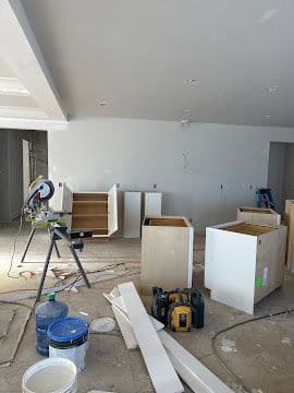 Kitchen cabinet installation in progress with base cabinets staged on site
