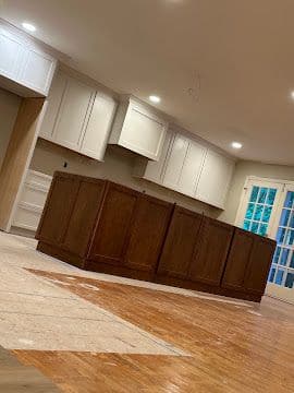 Kitchen with white upper cabinets and stained wood island cabinetry